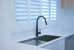 kitchen sink and window with plantation shutters